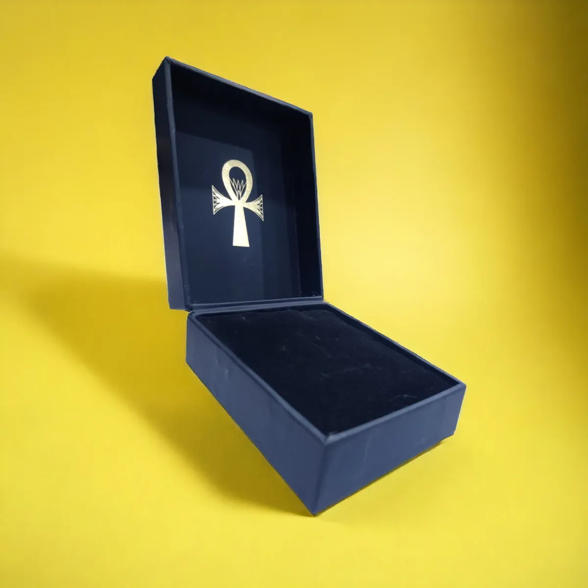 Navy rigid jewelry box open to show a pendant on a velvet insert