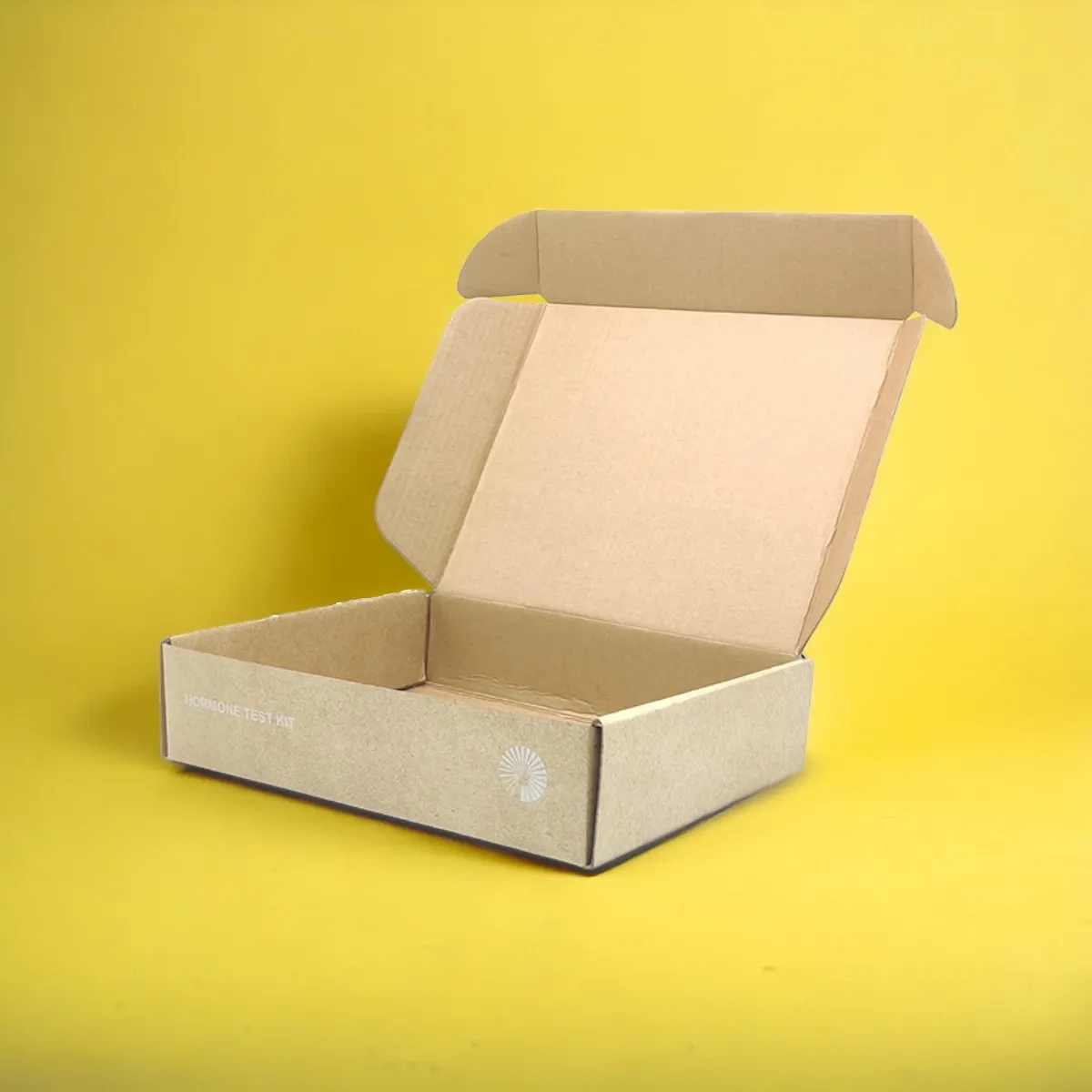 Two kraft E-flute mailer boxes with lids open