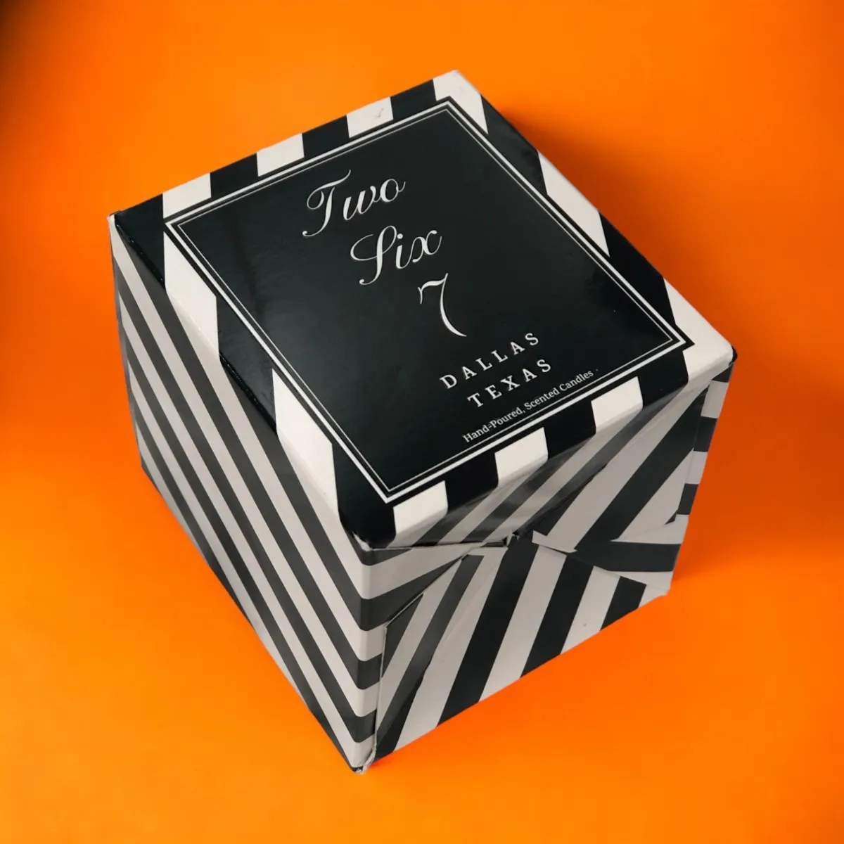 Striped candle carton with a black printed label panel