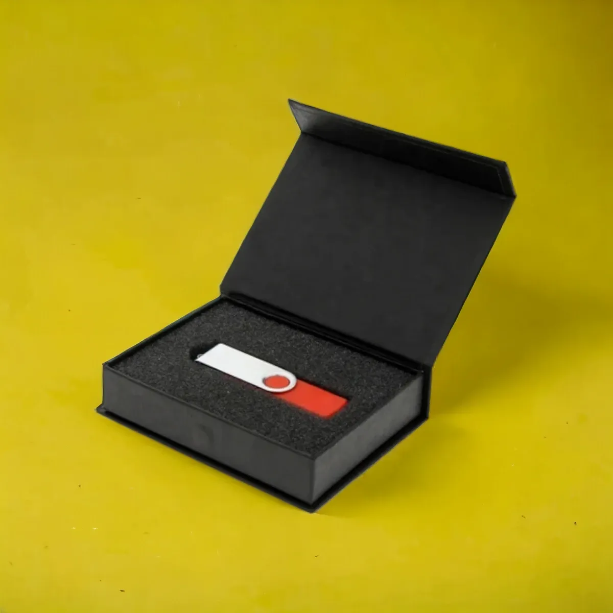 Black magnetic box with a foam insert holding a USB drive